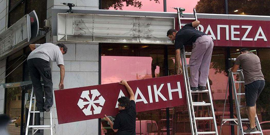 Workers removing LAIKI Bank signage from a building during closure linked to LAIKI lawsuit.