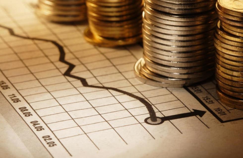 Stacks of coins placed on a financial chart showing market trends and economic performance.