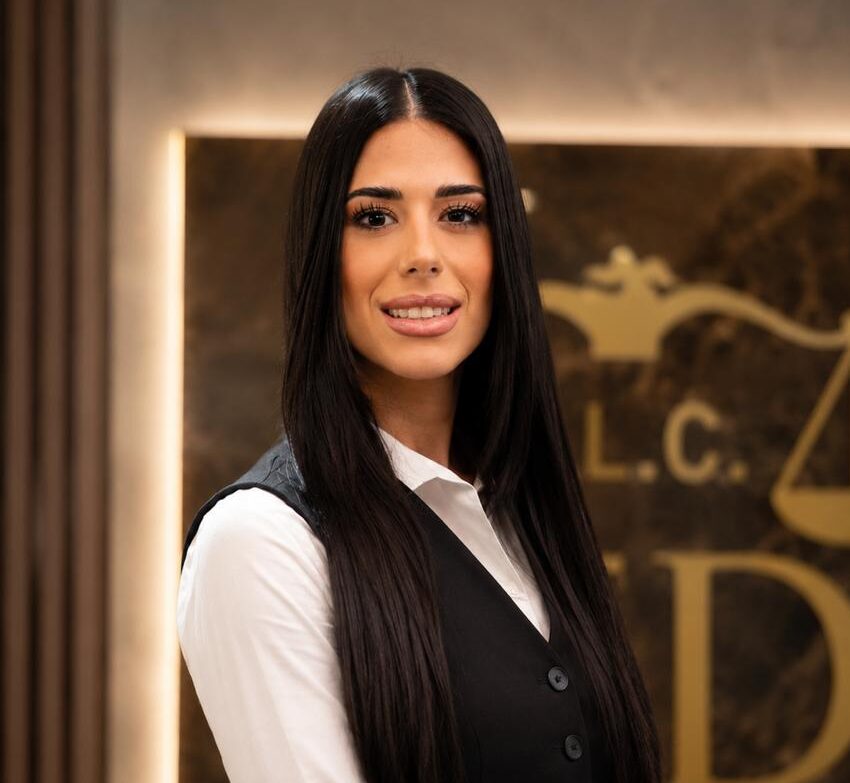 Professional portrait of Thekla Kaili in formal business attire, standing in the Demetriou Law Firm office and representing client-focused legal services in Cyprus.